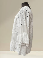Blouse bohème blanche en coton 100% avec détails en dentelle ajourée, manches évasées, signée Boutique Sylbelle.