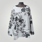 Blouse en lin à fleurs noires et blanches de Boutique Sylbelle, manches longues, col rond, coupe ample.