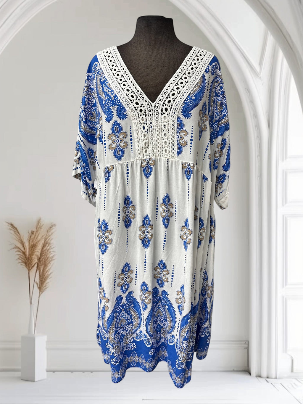 Robe bohème blanche et bleue en viscose avec un imprimé cachemire et un décolleté en V orné de dentelle. Boutique Sylbelle.