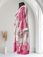 Robe bohème Boutique Sylbelle blanche avec un imprimé cachemire rose vif et des détails en dentelle sur le col.