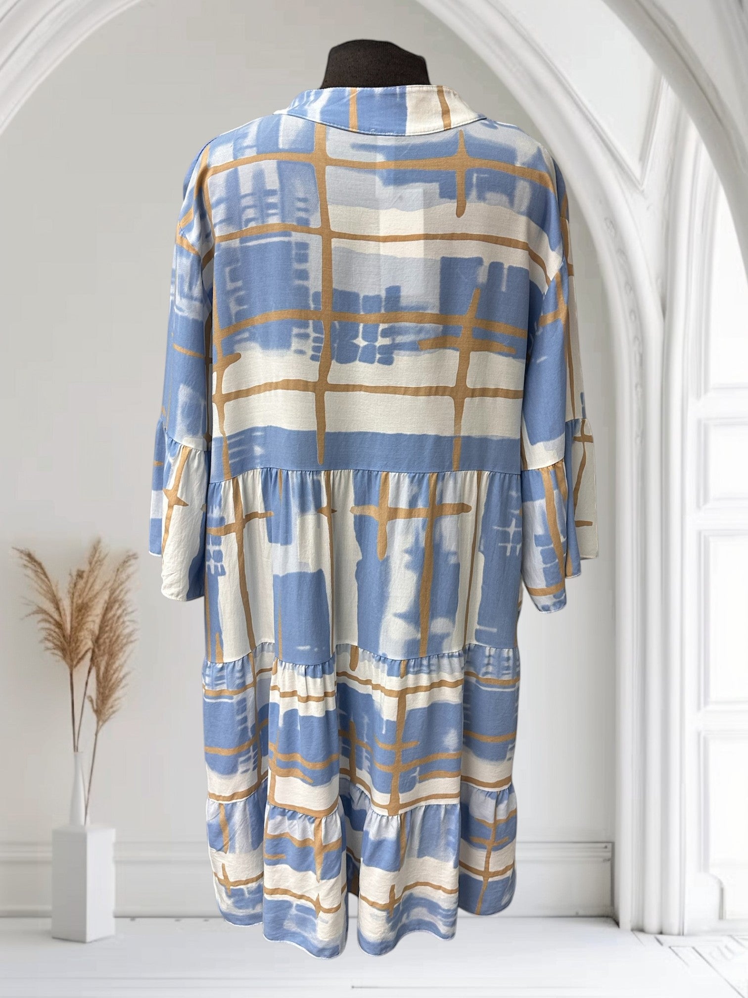 Robe Boutique Sylbelle à imprimé abstrait bleu et blanc avec des détails dorés, manches courtes évasées, coupe évasée à volants.